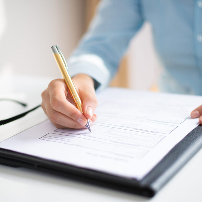 Closeup of business woman making notes in document